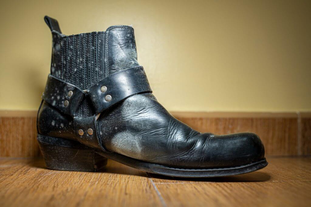 A badly water-damaged leather boot